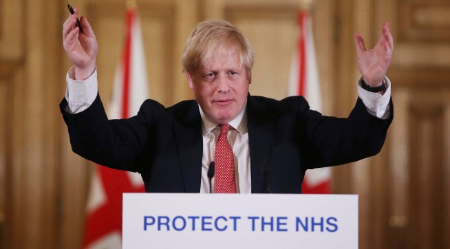 FILE - In this Sunday March 22, 2020 file photo British Prime Minister Boris Johnson gestures during his daily COVID 19 coronavirus press briefing to announce new measures to limit the spread of the virus, at Downing Street in London.  The British prime minister’s office says Boris Johnson will return to work Monday April 27, 2020, two weeks after he was discharged from a London hospital where he was treated for the new coronavirus. (Ian Vogler / Pool via AP, File)