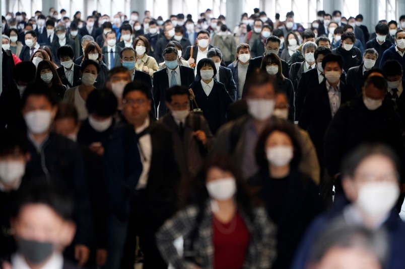 FILE - In this file April 27, 2020 photo, a station passageway is crowded with commuters wearing face mask in Tokyo. Under Japan’s coronavirus state of emergency, people have been asked to stay home. Many are not. Many still have to commute to their jobs despite risks of infection, while others continue to dine out, picnic in parks and crowd into grocery stores with scant regard for social distancing. (AP Photo/Eugene Hoshiko, File)