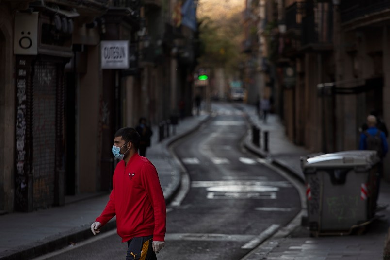 RAVAL DISTRICT, BARCELONA, SPAIN - 2020/04/05: A man wearing a face mask as a preventive measure against the COVID-19 coronavirus walks on an empty street. Due to the confinement order in Spain decreed by the Spanish President Pedro Sanchez to fight against the Coronavirus (Covid-19) the cities are practically empty. (Photo by Xavi Herrero/SOPA Images/LightRocket via Getty Images)