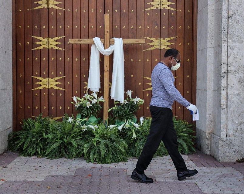An unidentified man passes the closed front doors of St. Mary's Cathedral as houses of worship closed their doors, but telecast their Sunday Easter services via social media, as large social and religious gatherings are prohibited due to shelter-in-place mandates by local and state governments on Easter Sunday, April 12, 2020 in Miami, Fla. (Carl Juste/Miami Herald/TNS)