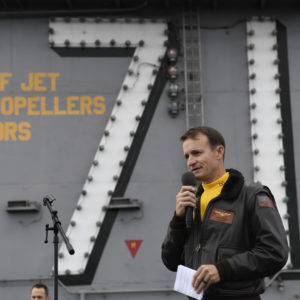 191115-N-IW125-1033 PACIFIC OCEAN (Nov. 14, 2019) Capt. Brett Crozier, commanding officer of the aircraft carrier USS Theodore Roosevelt (CVN 71), addresses the crew during an all-hands call on the ship’s flight deck. Theodore Roosevelt is conducting routine operations in the Eastern Pacific Ocean. (U.S. Navy photo by Mass Communication Specialist 3rd Class Nicholas Huynh)