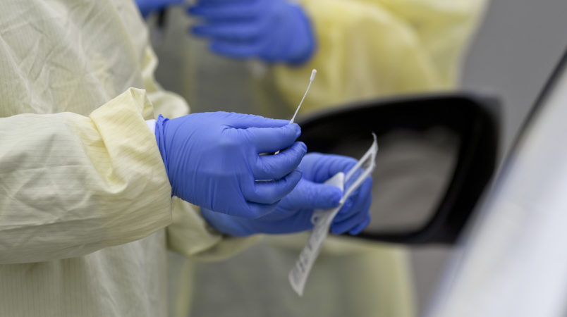 A detail photo of a nasal swab held by a Registered Nurse wearing gloves and a protective gown that she is about to use to do a test on a patient in their car at Penn State Health St. Joseph where they are conducting drive through coronavirus / COVID-19 testing and have taken extra precautions regarding entry to the hospital,  in Bern Township, PA Friday afternoon March 27, 2020.