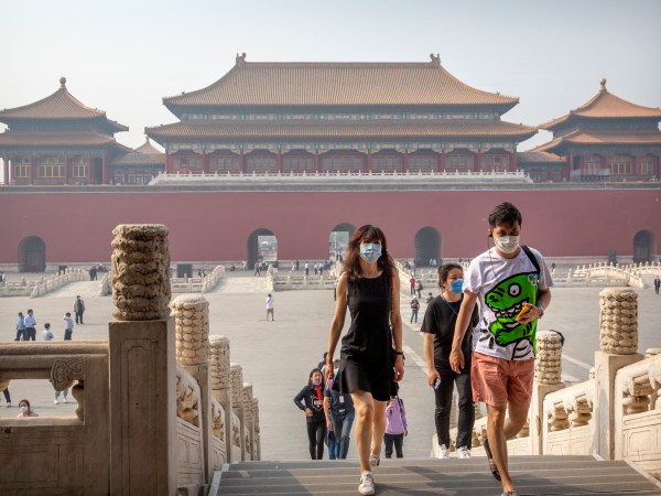 Visitors wearing face masks to protect against the new coronavirus walk through the Forbidden City in Beijing, Friday, May 1, 2020. The Forbidden City reopened beginning on Friday, China’s May Day holiday, to limited visitors after being closed to the public for more than three months during the coronavirus outbreak. (AP Photo/Mark Schiefelbein)