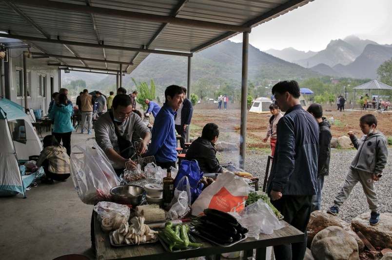 People gather for a barbecue at a scenic area in Fangshan district in Beijing, Monday, May 4, 2020, after authorities loosened up nationwide restrictions after months of lockdown over the coronavirus outbreak. China reported three new coronavirus cases Monday, all brought from overseas, and no additional deaths. (AP Photo/Andy Wong)