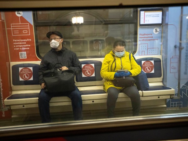 People wearing face masks and gloves to protect against coronavirus, observe social distancing guidelines as they ride a carriage in the subway on the escalator in Moscow, Russia, Wednesday, May 13, 2020. Wearing face masks and latex gloves is mandatory for people using Moscow's public transport. President Vladimir Putin declared an end to a partial economic shutdown across Russia due to the coronavirus pandemic, but he said that many restrictions will remain in place. (AP Photo/Alexander Zemlianichenko)