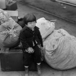 Japanese-American Child Waiting for Train to Owens Valley During Evacuation of Japanese-Americans from West Coast Areas under U.S. Army War Emergency Order, Los Angeles, California, USA, Russell Lee, Office of War Information, April 1942
