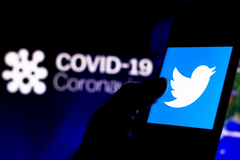 BRAZIL - 2020/04/08: In this photo illustration the Twitter logo seen displayed on a smartphone with a computer model of the COVID-19 coronavirus in the background. (Photo Illustration by Rafael Henrique/SOPA Images/LightRocket via Getty Images)