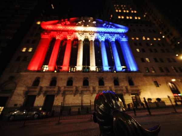 A view of the fearless girl with the New York Stock Exchange on the background lit in different colors as support for Frontliners during Coronavirus pandemic on May 5, 2020. (Photo by John Nacion/NurPhoto)