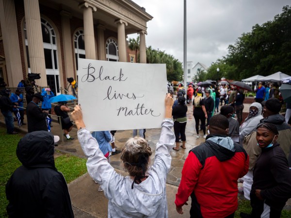 A group of protesters gather outside the Glynn County Courthouse while a preliminary hearing is being held inside for for Travis McMichael, Gregory McMichael and William Bryan, Thursday, June 4, 2020, in Brunswick, Ga. The three are accused of shooting of Ahmaud Arbery while he ran through their neighborhood in February. (AP Photo/Stephen B. Morton)