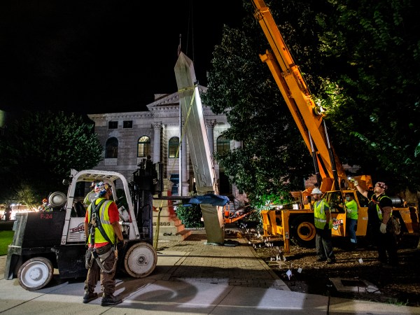 Workers remove a Confederate monument with a crane on Thursday, June 18, 2020, in Decatur, Georgia. The 30-foot obelisk in Decatur Square, erected by the United Daughters of the Confederacy in 1908, was order to be removed by a judge and placed in storage indefinitely. (AP Photo/Ron Harris)