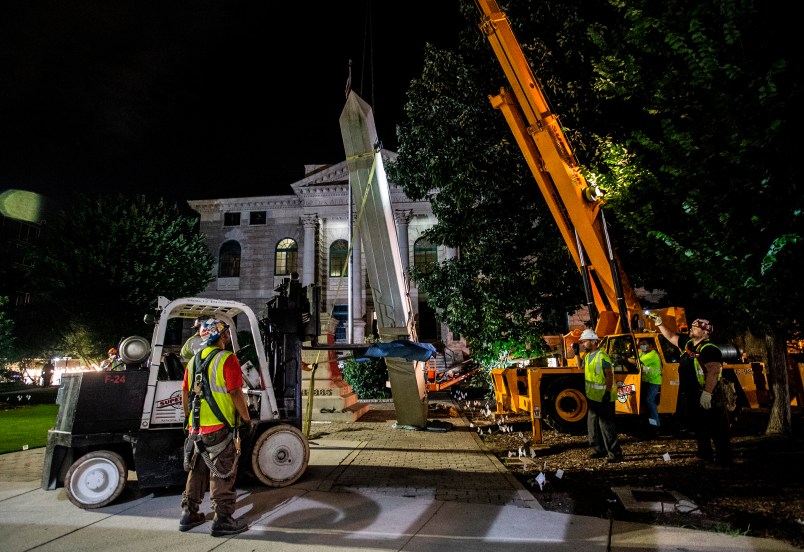 Workers remove a Confederate monument with a crane on Thursday, June 18, 2020, in Decatur, Georgia. The 30-foot obelisk in Decatur Square, erected by the United Daughters of the Confederacy in 1908, was order to be removed by a judge and placed in storage indefinitely. (AP Photo/Ron Harris)