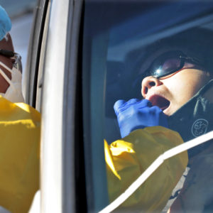 People get tested for COVID-19 at a drive through testing site hosted by the Puente Movement migrant justice organization Saturday, June 20, 2020, in Phoenix. Latinos are especially vulnerable to infection because they tend to live in tight quarters with multiple family members and have jobs that expose them to others. They also have a greater incidence of health conditions like diabetes that put them at higher risk for contracting COVID-19. (AP Photo/Matt York)