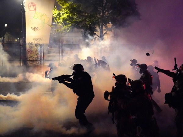 PORTLAND, OR - JULY 24: Federal officers deploy tear gas and less-lethal munitions while dispersing a crowd of about a thousand protesters in front of the Mark O. Hatfield U.S. Courthouse on Thursday, July 24, 2020 in Portland, Oregon.  Protesters continued to clash with federal officers Friday morning as President Trump announced plans to deploy similar federal forces to other U.S. cities. (Photo by Nathan Howard/Getty Images)