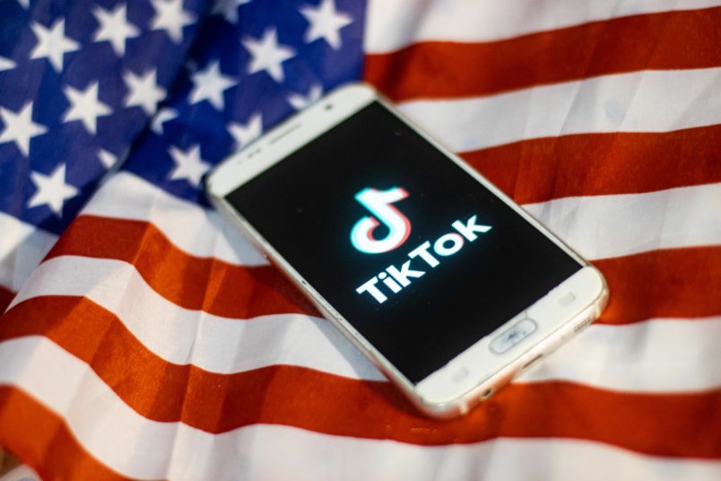 TikTok closeup logo displayed on a phone screen, smartphone on the American flag or U.S. flag, the national flag of the United States are seen in this multiple exposure illustration. Tik Tok is a Chinese video-sharing social networking service owned by a Beijing based internet technology company, ByteDance.  It is used to create short dance, lip-sync, comedy and talent videos. ByteDance launched TikTok app for iOS and Android in 2017 and earlier in September 2016 Douyin fror the market in China. TikTok became the most downloaded app in the US in October 2018. President of the USA Donald Trump is threatening and planning to ban the popular video sharing app TikTok from the US because of the security risk.  On August 3, 2020 in Thessaloniki, Greece.(Photo by Nicolas Economou/NurPhoto)