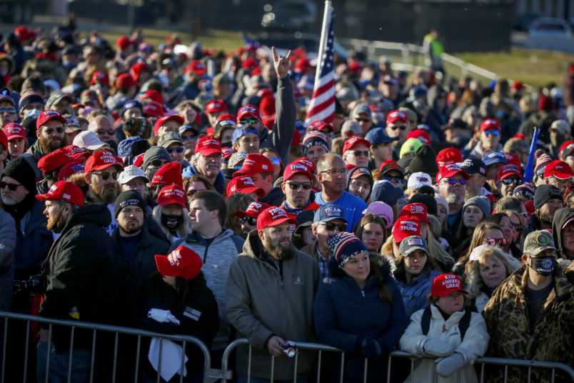 People wait outside the airport before a campaign rally with President Donald Trump Friday, Oct. 30, 2020, in Rochester, Minn. (AP Photo/Bruce Kluckhohn)