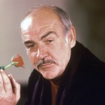 Actor Sean Connery holds a rose in his hand as he talks about his new movie "The Name of the Rose" at a news conference in London, England, Jan. 23, 1987.  (AP Photo/Gerald Penny)