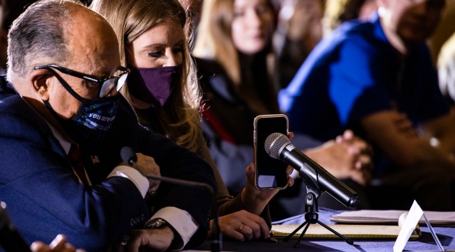 GETTYSBURG, PA - NOVEMBER 25: Jenna Ellis, a member of President Donald Trumps legal team, holds up a cell phone to the microphone so President Trump can speak during a Pennsylvania Senate Majority Policy Committee public hearing Wednesday at the Wyndham Gettysburg hotel to discuss 2020 election issues and irregularities on November 25, 2020 in Gettysburg, Pennsylvania. Giuliani is continuing his push to over turn election results in the courts. (Photo by Samuel Corum/Getty Images) *** Local Caption *** Jenna Ellis; Rudy Giuliani