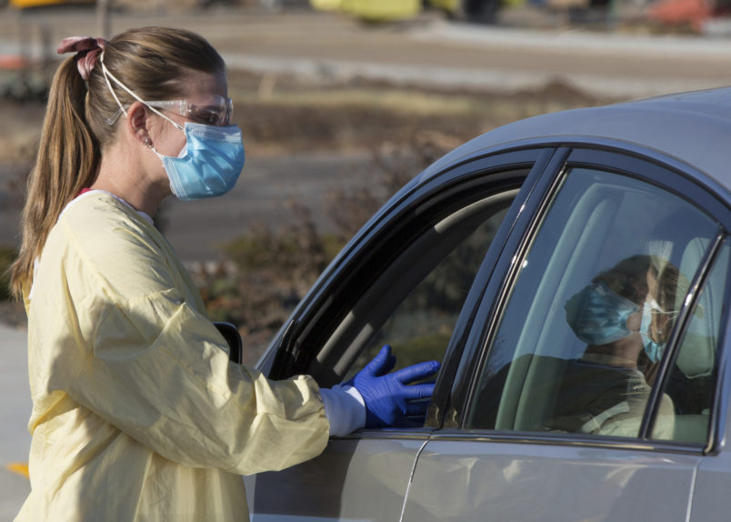 HOLD FOR KEITH RIDLER STORY Physician assistant Nicole Thomas conducts a COVID-19 examination in the parking lot at Primary Health in Boise, Idaho, on Tuesday, Nov. 24, 2020. (AP Photo/Otto Kitsinger)
