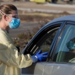 HOLD FOR KEITH RIDLER STORY Physician assistant Nicole Thomas conducts a COVID-19 examination in the parking lot at Primary Health in Boise, Idaho, on Tuesday, Nov. 24, 2020. (AP Photo/Otto Kitsinger)