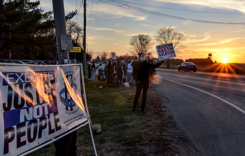 Protesters line Prairieton Road across from the Federal Death Chamber in Terre Haute, IN. during a protest against the execution of Brandon Bernard on Thursday evening. (Austen Leake/Tribune-Star via AP)