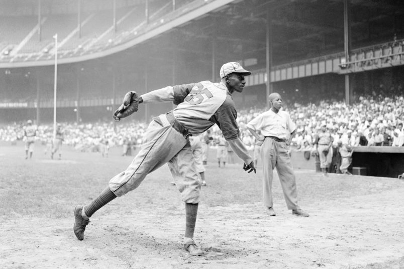 FILE - In this Aug. 2, 1942, file photo, Kansas City Monarchs pitcher Leroy Satchel Paige warms up at New York's Yankee Stadium before a Negro League game between the Monarchs and the New York Cuban Stars.  Major League Baseball has reclassified the Negro Leagues as a major league and will count the statistics and records of its 3,400 players as part of its history. The league said Wednesday, Dec. 16, 2020, it was “correcting a longtime oversight in the game's history” by elevating the Negro Leagues on the centennial of its founding.  (AP Photo/Matty Zimmerman, File)
