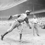 FILE - In this Aug. 2, 1942, file photo, Kansas City Monarchs pitcher Leroy Satchel Paige warms up at New York's Yankee Stadium before a Negro League game between the Monarchs and the New York Cuban Stars.  Major League Baseball has reclassified the Negro Leagues as a major league and will count the statistics and records of its 3,400 players as part of its history. The league said Wednesday, Dec. 16, 2020, it was “correcting a longtime oversight in the game's history” by elevating the Negro Leagues on the centennial of its founding.  (AP Photo/Matty Zimmerman, File)