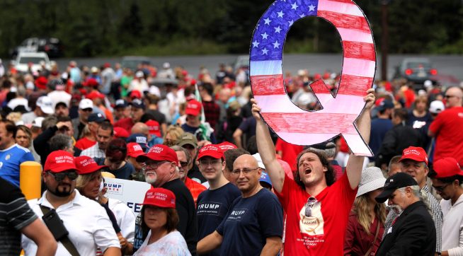WILKES BARRE, PA - AUGUST 02: David Reinert holds up a large "Q" sign while waiting in line on August 2, 2018 at the Mohegan Sun Arena at Casey Plaza in Wilkes Barre, Pennsylvania to see President Donald J. Trump at his rally. "Q" is a conspiracy theory group that has been seen at recent rallies.    (Photo by Rick Loomis/Getty Images)