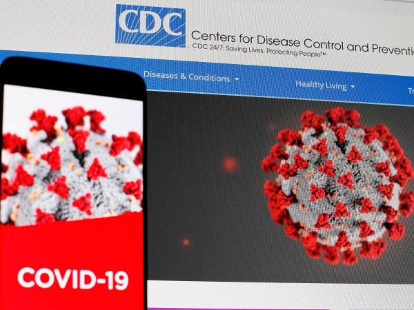 UKRAINE - 2020/04/29: In this photo illustration the Centers of Disease Control and Prevention (CDC) web page displayed in internet on a pc screen and a coronavirus image on a mobile phone.The number of the COVID-19 coronavirus confirmed cases in the United States exceeded one million and exceeded three million in the world, according of COVID-19 Dashboard by the Center for Systems Science and Engineering (CSSE) at Johns Hopkins University (JHU). The World Health Organization declared the coronavirus a global pandemic on 11 March 2020. (Photo Illustration by Pavlo Gonchar/SOPA Images/LightRocket via Getty Images)