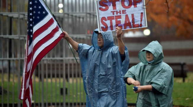 WILKES-BARRE, PENNSYLVANIA, UNITED STATES - 2020/11/11: A protester holds a placard and a flag during the demonstration.A group of approximately 25 people in support of Donald Trump marched around Public Square shouting "Stop the Steal" and demanding a recount of votes in Pennsylvania. (Photo by Aimee Dilger/SOPA Images/LightRocket via Getty Images)
