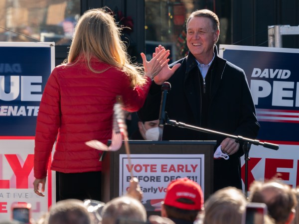 MILTON, GA - DECEMBER 21: Senators Kelly Loeffler and David Perdue high five each other as Perdue takes the stage to speak during a campaign event on December 21, 2020 in Milton, Georgia. The two Georgia U.S. Senate runoff elections on Jan. 5 will decide control of the Senate. (Photo by Elijah Nouvelage/Getty Images)