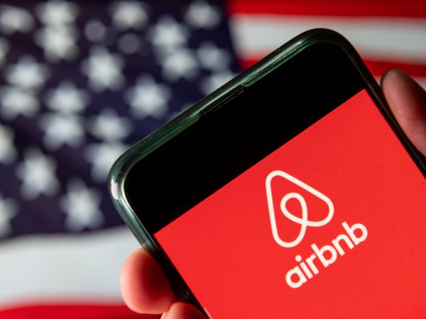 CHINA - 2020/08/15: In this photo illustration the American online marketplace and hospitality service Airbnb logo is seen on an Android mobile device with United States of America flag in the background. (Photo Illustration by Budrul Chukrut/SOPA Images/LightRocket via Getty Images)
