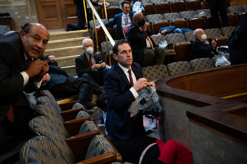 UNITED STATES - JANUARY 6: Rep. Jason Crow, D-Colo.,  and other members take cover as protesters attempt to disrupt the joint session of Congress to certify the Electoral College vote on Wednesday, January 6, 2021. (Photo By Tom Williams/CQ Roll Call)