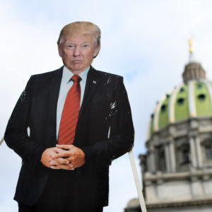 HARRISBURG, PA - JANUARY 17: A cardboard effigy of President Donald Trump is lowered while people demonstrate against the president outside the Pennsylvania Capitol Building on January 17, 2021 in Harrisburg, Pennsylvania. Supporters of President Trump are expected to gather at state capitol buildings throughout the nation today to protest the presidential election results and the upcoming inauguration of President-elect Joe Biden. (Photo by Mark Makela/Getty Images)