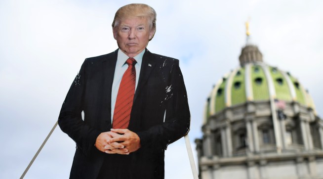 HARRISBURG, PA - JANUARY 17: A cardboard effigy of President Donald Trump is lowered while people demonstrate against the president outside the Pennsylvania Capitol Building on January 17, 2021 in Harrisburg, Pennsylvania. Supporters of President Trump are expected to gather at state capitol buildings throughout the nation today to protest the presidential election results and the upcoming inauguration of President-elect Joe Biden. (Photo by Mark Makela/Getty Images)
