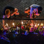 DAYTON, OH - AUGUST 5:Samuel Klug, L, and John Neff place candles around a makeshift memorial at the scene of a mass shooting in the city's historic Oregon District where Connor Betts used an "AR-15-like" rifle about 24 hours earlier to kill nine people, including his sister, and injure 27 others, on Monday, August 5, 2019, in Dayton, OH. Neff's friend is one of the 27 people injured, shot through the hand. "I've never been through something like this before," Neff said. "This is pretty painful. I don't have kids, but I would hate to be feeling what a parent is going through right now. This is awful." He added, "I don't think thoughts and prayers are going to protect us anymore. I don't think they ever have. We need some gun laws that are going to protect us, and protect our husbands and wives and kids. I think we need people in power that are going to protect our future. If we continue to let this happen, who knows if we're going to have a future." The attack came less than a day after a man with a high-powered weapon killed 20 people in El Paso, Texas, and a week after a gunman killed three people and wounded 12 at the Gilroy Garlic Festival in California. (Photo by Jahi Chikwendiu/The Washington Post).