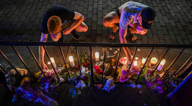 DAYTON, OH - AUGUST 5:Samuel Klug, L, and John Neff place candles around a makeshift memorial at the scene of a mass shooting in the city's historic Oregon District where Connor Betts used an "AR-15-like" rifle about 24 hours earlier to kill nine people, including his sister, and injure 27 others, on Monday, August 5, 2019, in Dayton, OH. Neff's friend is one of the 27 people injured, shot through the hand. "I've never been through something like this before," Neff said. "This is pretty painful. I don't have kids, but I would hate to be feeling what a parent is going through right now. This is awful." He added, "I don't think thoughts and prayers are going to protect us anymore. I don't think they ever have. We need some gun laws that are going to protect us, and protect our husbands and wives and kids. I think we need people in power that are going to protect our future. If we continue to let this happen, who knows if we're going to have a future." The attack came less than a day after a man with a high-powered weapon killed 20 people in El Paso, Texas, and a week after a gunman killed three people and wounded 12 at the Gilroy Garlic Festival in California. (Photo by Jahi Chikwendiu/The Washington Post).