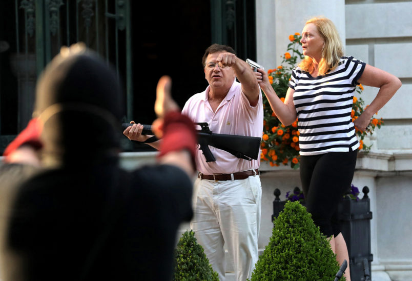 Armed homeowners Mark T. and Patricia N. McCloskey stand in front their house as they confront protesters marching to St. Louis Mayor Lyda Krewson's house on June 28, 2020. The protesters called for Krewson's resignation for releasing the names and addresses of residents who suggested defunding the police department. (Laurie Skrivan/St. Louis Post-Dispatch/TNS)