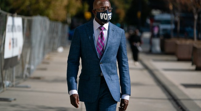 ATLANTA, GA - OCTOBER 21: Democratic U.S. senatorial candidate Raphael Warnock walks to State Farm Arena to cast his ballot on October 21, 2020 in Atlanta, Georgia. (Photo by Elijah Nouvelage/Getty Images)