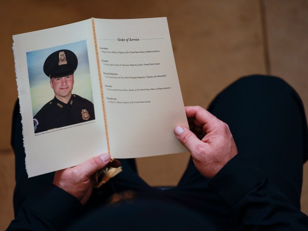 WASHINGTON, DC - FEBRUARY 3: A U.S. Capitol Police Officer holds a program for the ceremony memorializing U.S. Capitol Police Officer Brian D. Sicknick, 42, as he lies in honor in the Rotunda of the Capitol on Wednesday, February 3, 2021. Officer Sicknick was responding to the riot at the U.S. Capitol on Wednesday, January 6, 2021, when he was fatally injured while physically engaging with the mob. Members of Congress will pay tribute to the officer on Wednesday morning before his burial at Arlington National Cemetery. (Photo by Demetrius Freeman/The Washington Post/POOL)