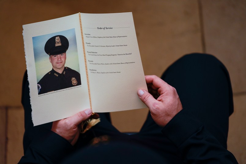 WASHINGTON, DC - FEBRUARY 3: A U.S. Capitol Police Officer holds a program for the ceremony memorializing U.S. Capitol Police Officer Brian D. Sicknick, 42, as he lies in honor in the Rotunda of the Capitol on Wednesday, February 3, 2021. Officer Sicknick was responding to the riot at the U.S. Capitol on Wednesday, January 6, 2021, when he was fatally injured while physically engaging with the mob. Members of Congress will pay tribute to the officer on Wednesday morning before his burial at Arlington National Cemetery. (Photo by Demetrius Freeman/The Washington Post/POOL)