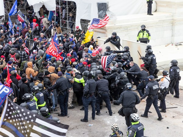 WASHINGTON DC, DISTRICT OF COLUMBIA, UNITED STATES - 2021/01/06: Pro-Trump protesters and police clash on top of the Capitol building. Rioters broke windows and breached the Capitol building in an attempt to overthrow the results of the 2020 election. Police used batons and tear gas grenades to eventually disperse the crowd. Rioters used metal bars and tear gas as well against the police. (Photo by Lev Radin/Pacific Press/LightRocket via Getty Images)