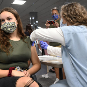 MELBOURNE, FLORIDA, UNITED STATES - 2021/05/17: A nurse gives Sherri Trimble, 15, a shot of the vaccine at a vaccination clinic at Health First Medical Centre.On May 12, 2021, the CDC approved the use of the Pfizer BioNTech vaccine in 12 through 15-year-old adolescents. Vaccinating this age group is seen as a keyway for middle and high schools to reopen fully by this fall. (Photo by Paul Hennessy/SOPA Images/LightRocket via Getty Images)