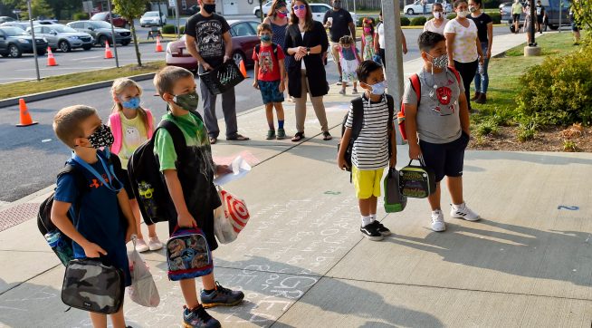 Students and parents wait outside Perry Elementary School on the first day of school. At Perry Elementary School in Shoemakersville, PA Thursday morning August 27, 2020 for the first day of in person school of the school year. The Hamburg School District, which Perry Elementary is part of, is the only school district in Berks County that is opening 5 days a week for in person instruction during the coronavirus / COVID-19 outbreak.