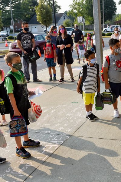 Students and parents wait outside Perry Elementary School on the first day of school. At Perry Elementary School in Shoemakersville, PA Thursday morning August 27, 2020 for the first day of in person school of the school year. The Hamburg School District, which Perry Elementary is part of, is the only school district in Berks County that is opening 5 days a week for in person instruction during the coronavirus / COVID-19 outbreak.