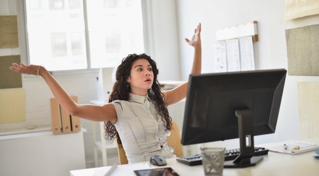 Businesswoman frustrated at computer at desk in office