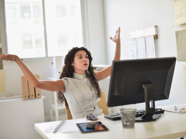 Businesswoman frustrated at computer at desk in office