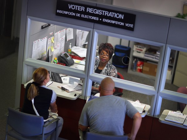 MIAMI, FL - OCTOBER 01:  Dorothy Torrence, from the Miami-Dade Elections Department, helps Yarelis Alvarez (L) and Alberto Alvarez fill out their voter registration forms on October 1, 2012 in Miami, Florida. As the October 9th deadline for people to register to vote in the upcoming election approaches according to the Florida Department of State, the number of people registering to vote is now averaging between 1,500 and 3,000 a day. After months of the Democrats questioning the motives of the Republican led legislator to purge non citizens and roll back early voting, the Republican Party was accused of using a firm to register voters that was providing false voter registration information. (Photo by Joe Raedle/Getty Images)