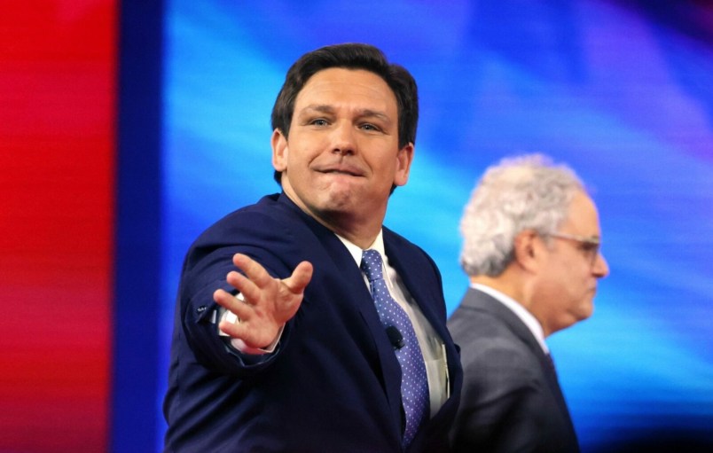 Florida Gov. Ron DeSantis tosses hats into the crowd as he takes the stage at the 2022 CPAC conference at the Rosen Shingle Creek in Orlando, Florida, on Thursday, Feb. 24, 2022. (Joe Burbank/Orlando Sentinel/Tribune News Service via Getty Images)