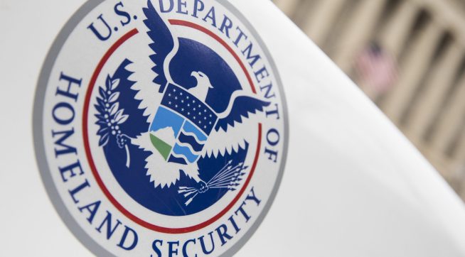 U.S. Department of Homeland Security logo on a white law enforcement vehicle.